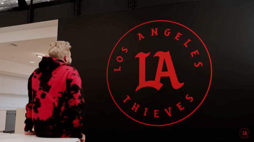 100 Thieves owner looking at LA Thieves logo on a wall.