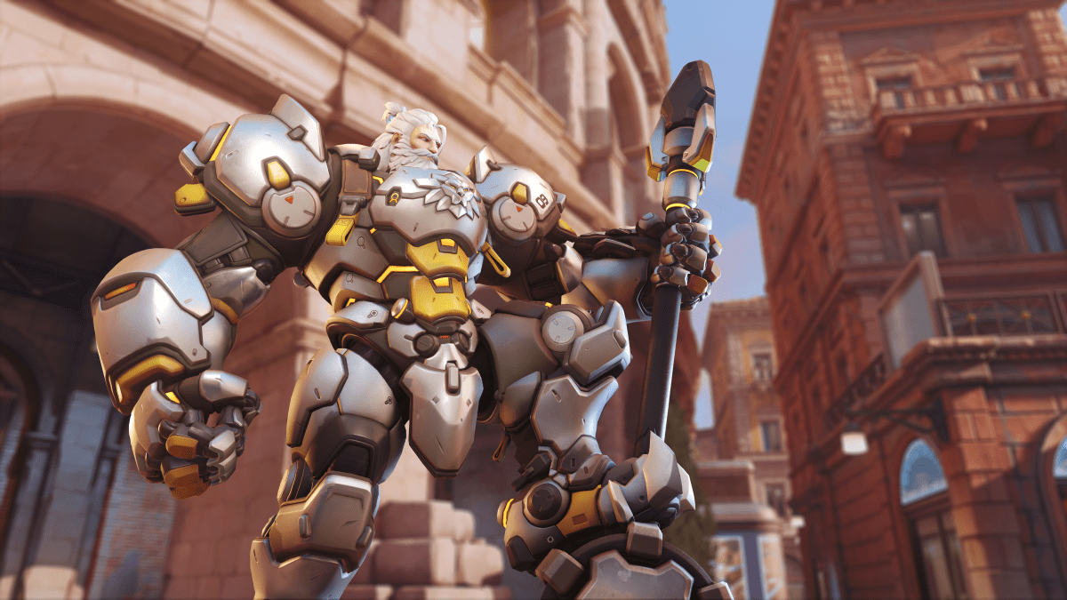 Reinhardt wears heavy armor and poses with his hammer in Overwatch 2.