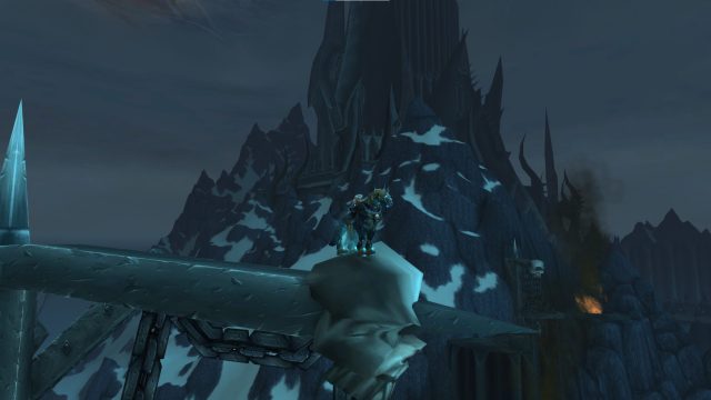 An in-game WoW screenshot of the undead horse, Invincible, flying high above Icecrown Citadel in Northrend.
