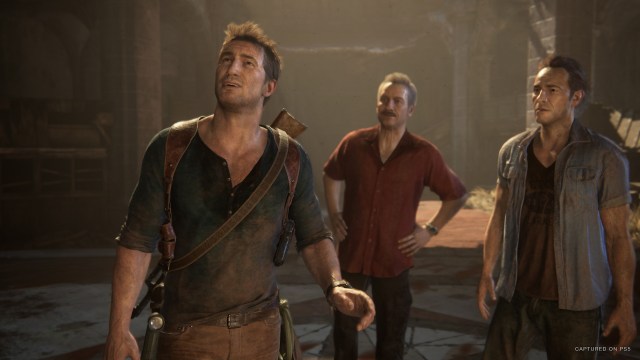 Nathan Drake stands with his companions in a damaged building in Uncharted.