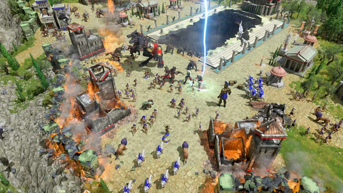 Armies clashing together with burning buildings and mythical units in the background