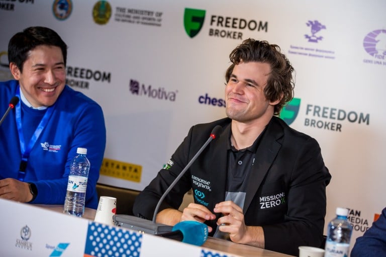 World chess number one Magnus Carlsen sits smiling at a press conference.