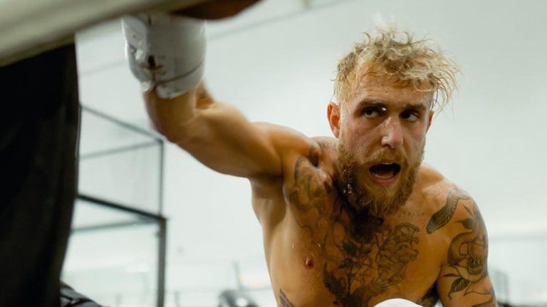 Jake Paul swings a gloved fist at a training pad