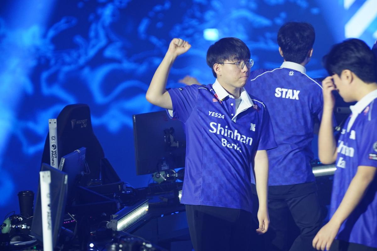 DRX's BuZz holds up a fist on the VCT Pacific stage after DRX's win over T1.
