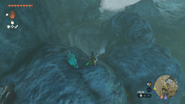 Link stands atop a pile of rocks. A waterfall flows down them, indicating that there is an open cavern beneath ground.