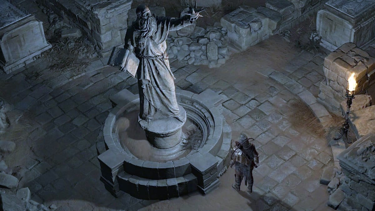 A Diablo 4 character standing beside a large statue.