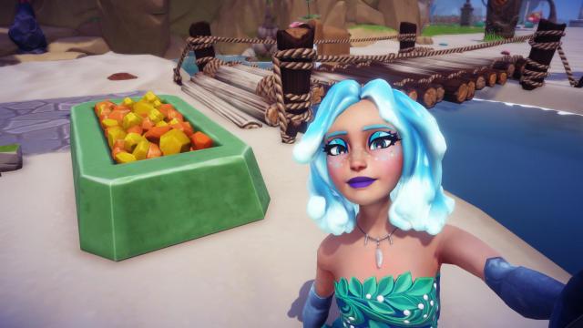The player taking a selfie with a container filled with orange and yellow rocks that is actually Olaf's parasol.