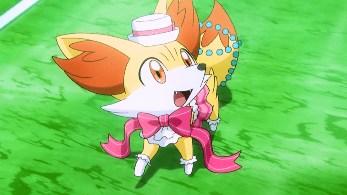 Fennekin smiling in a pink costume in the Pokémon anime.