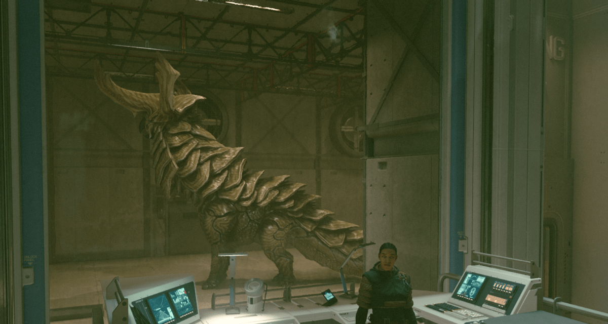 A character standing beside computers in Starfield, with a large dinosaur-like skeleton in the background.