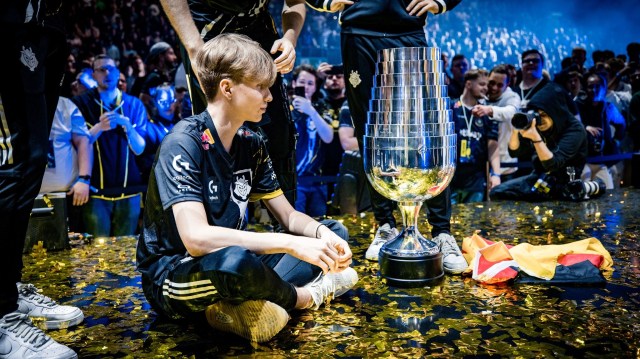 Photo of Russian CS:GO player m0NESY sitting in front of the IEM Cologne 2023 trophy after G2 defeated ENCE in the grand finals.