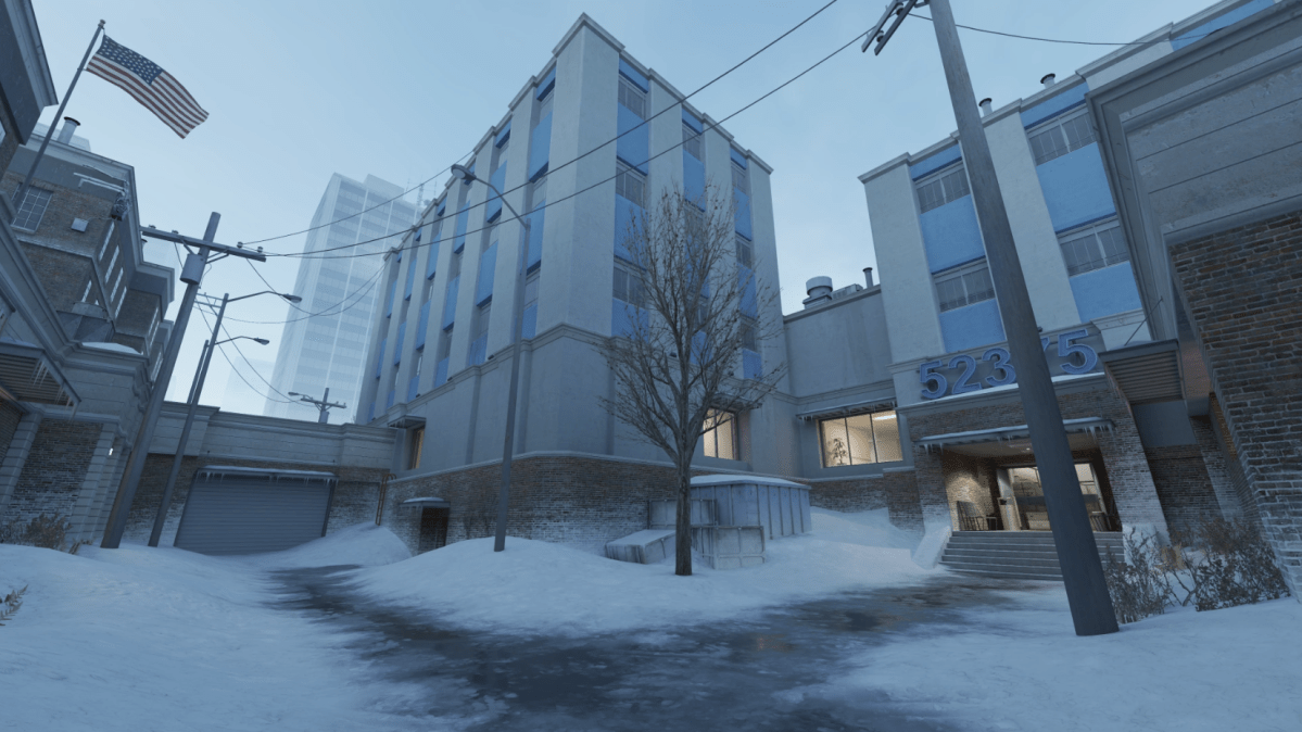 Official image of CS:GO hostage rescue map Office. It has plenty of snow, buildings, and one U.S. flag.