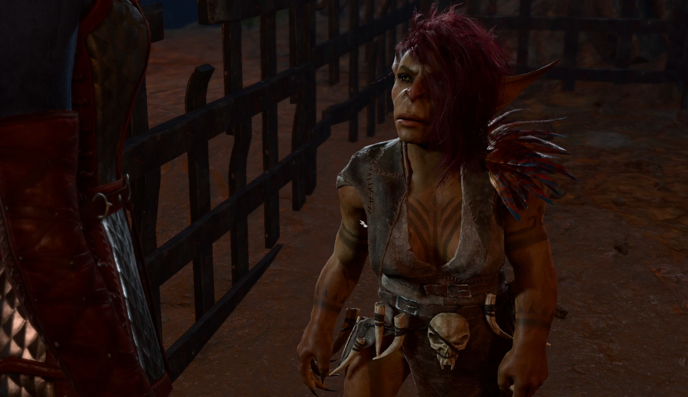 A red-haired goblin with tattoos on her chest stands in front of an open cell in Baldur's Gate 3.