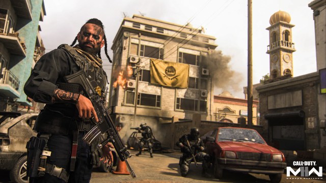 A CoD character wields a rifle while other soliders with weapons fight in a dusty city behind him.