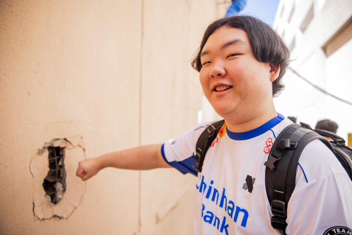 DRX's MaKo poses next to a broken wall, making a pose to look like he punched the wall to break it himself.