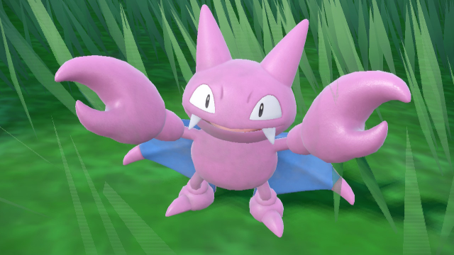 Gligar, a purple bat-like creature with two pincers and blue wings, stands against a grassy background in Pokémon Scarlet and Violet's The Teal Mask DLC.