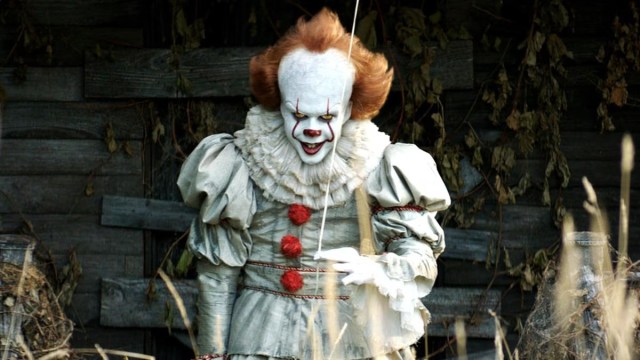 Pennywise the Clown staring at the camera while holding a balloon