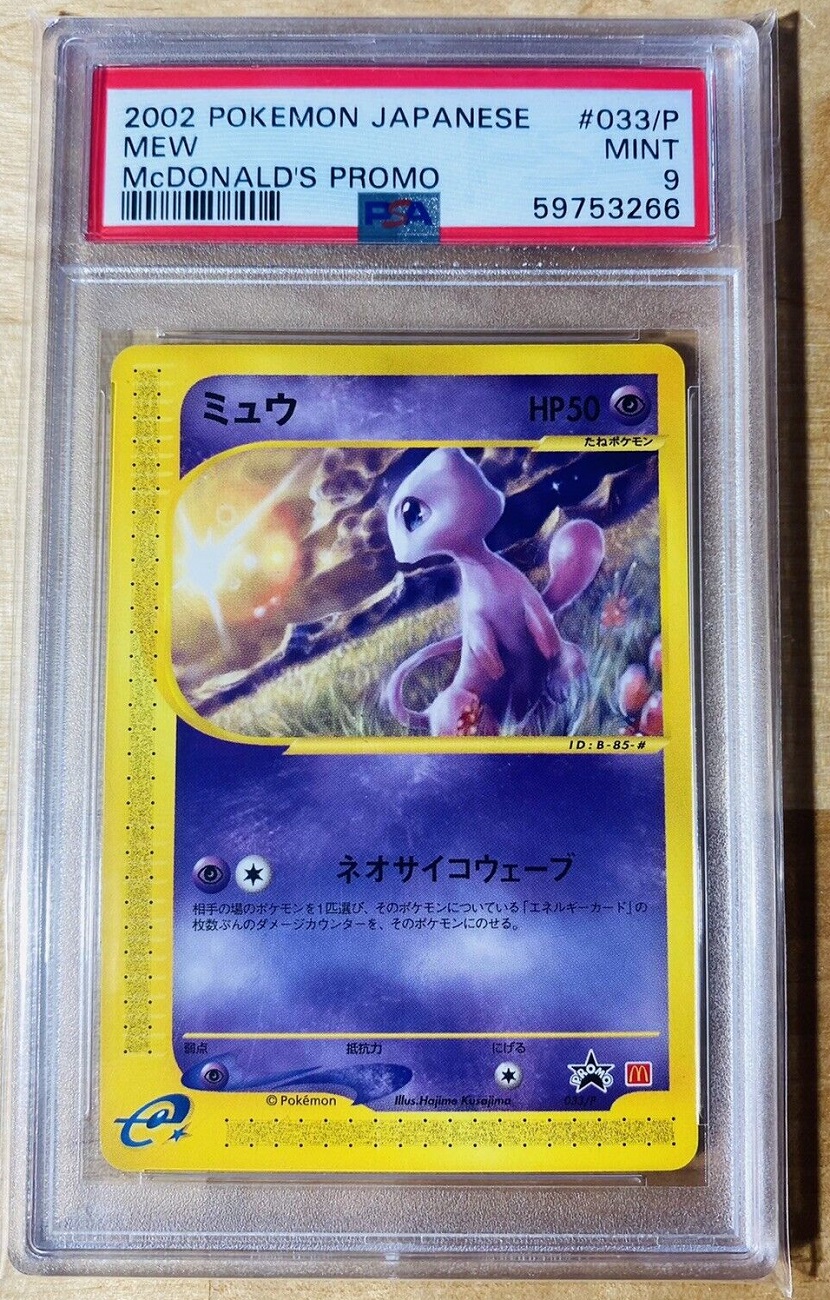There is a card of Mew in a case. The Mew is in a field, with a bright sun behind it. 