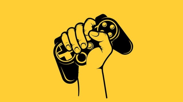 A hand holding up a video game controller against a yellow background