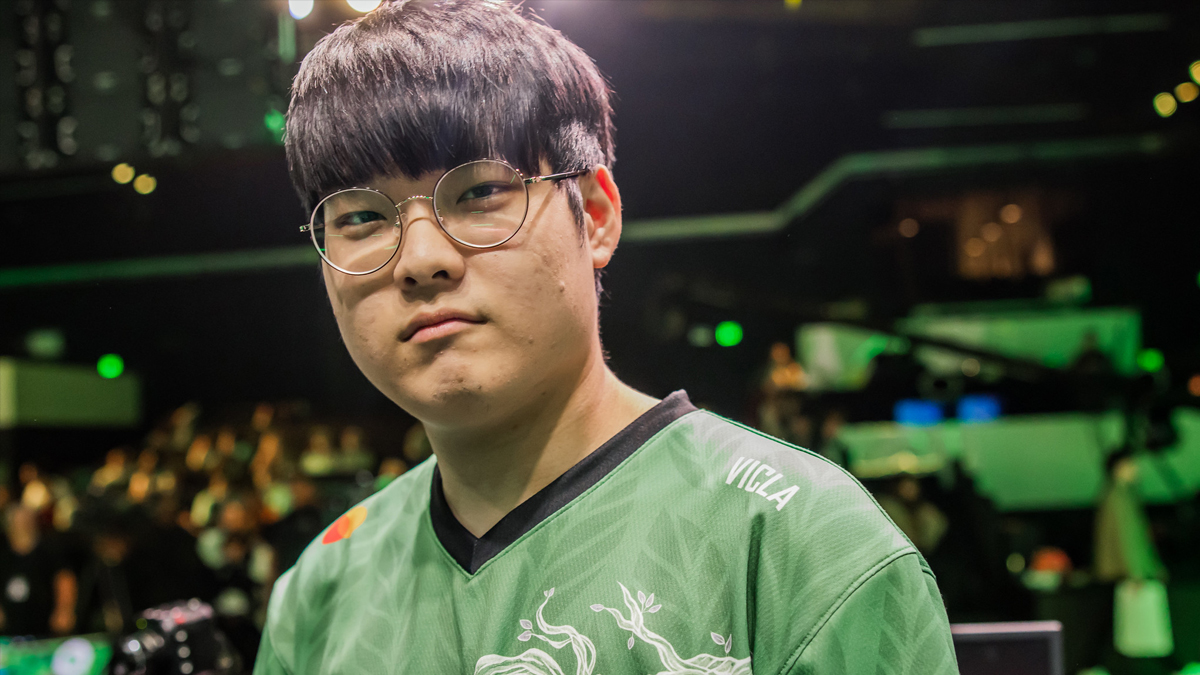 VicLa, a League of Legends player, wearing a green FlyQuest jersey and looking into a camera in front of the LCS audience.