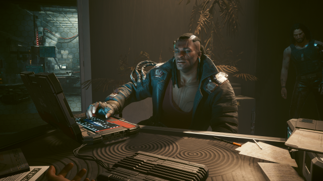 Placide sitting across from V and working on a terminal (Cyberpunk 2077).