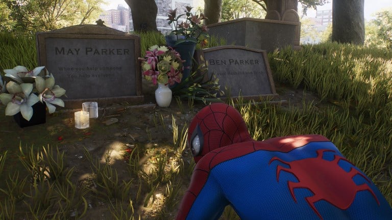 Spider-Man kneeling by the graves of Aunt May and Uncle Ben.