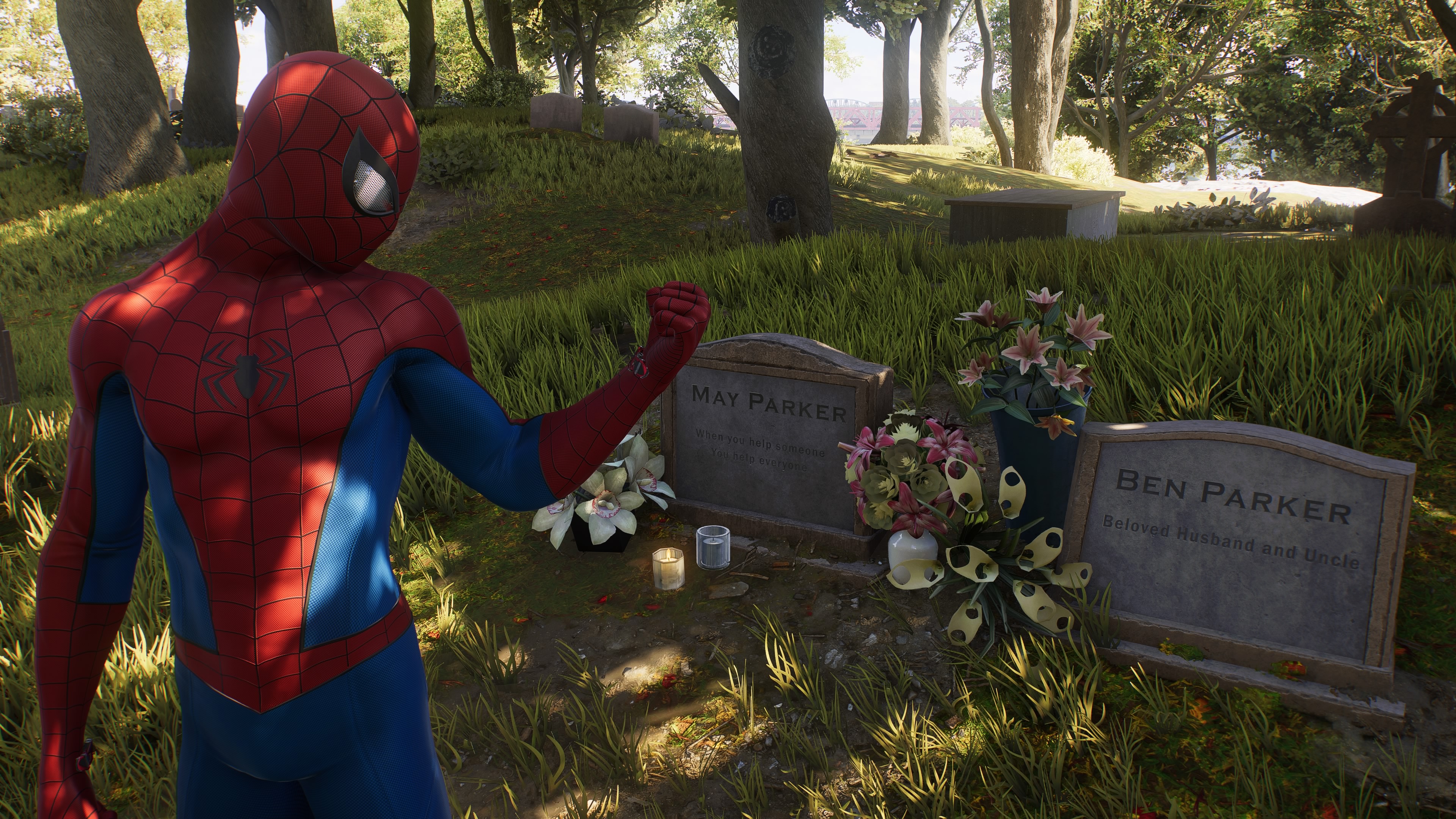 Spider-Man holding out an angry fist at the graves of Aunt May and Uncle Ben.