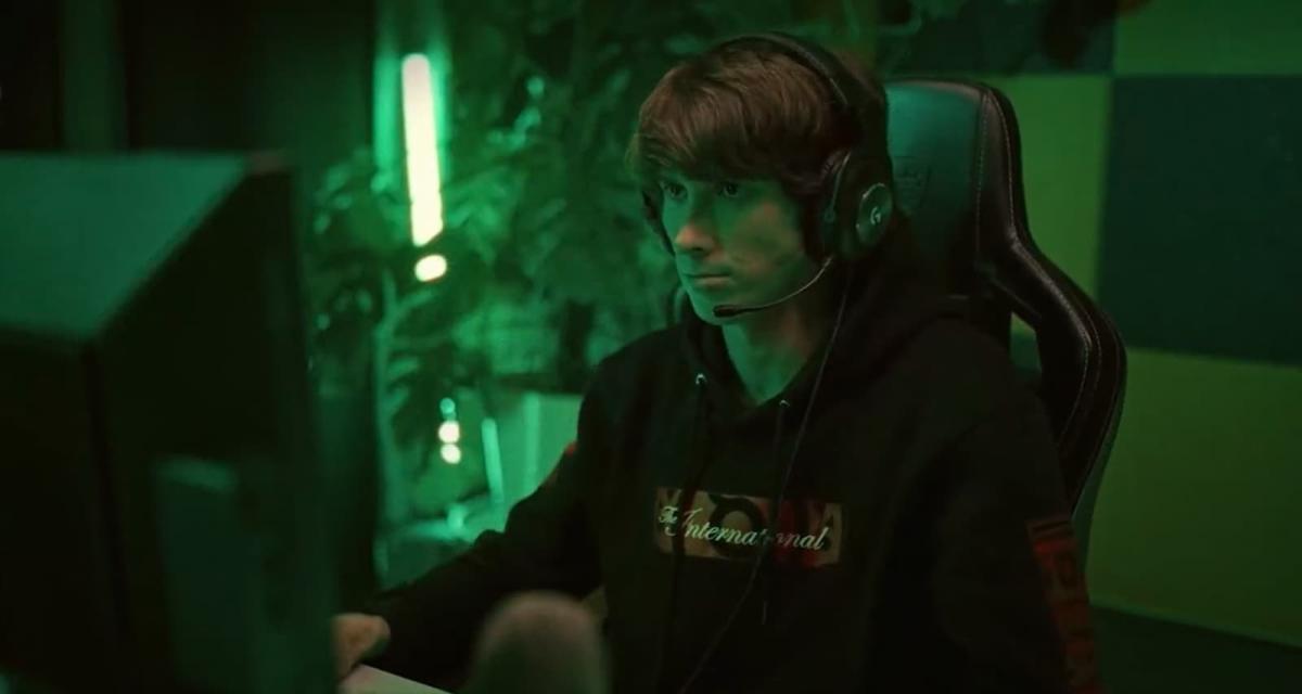 Dendi illuminated by a green light while playing Dota 2.