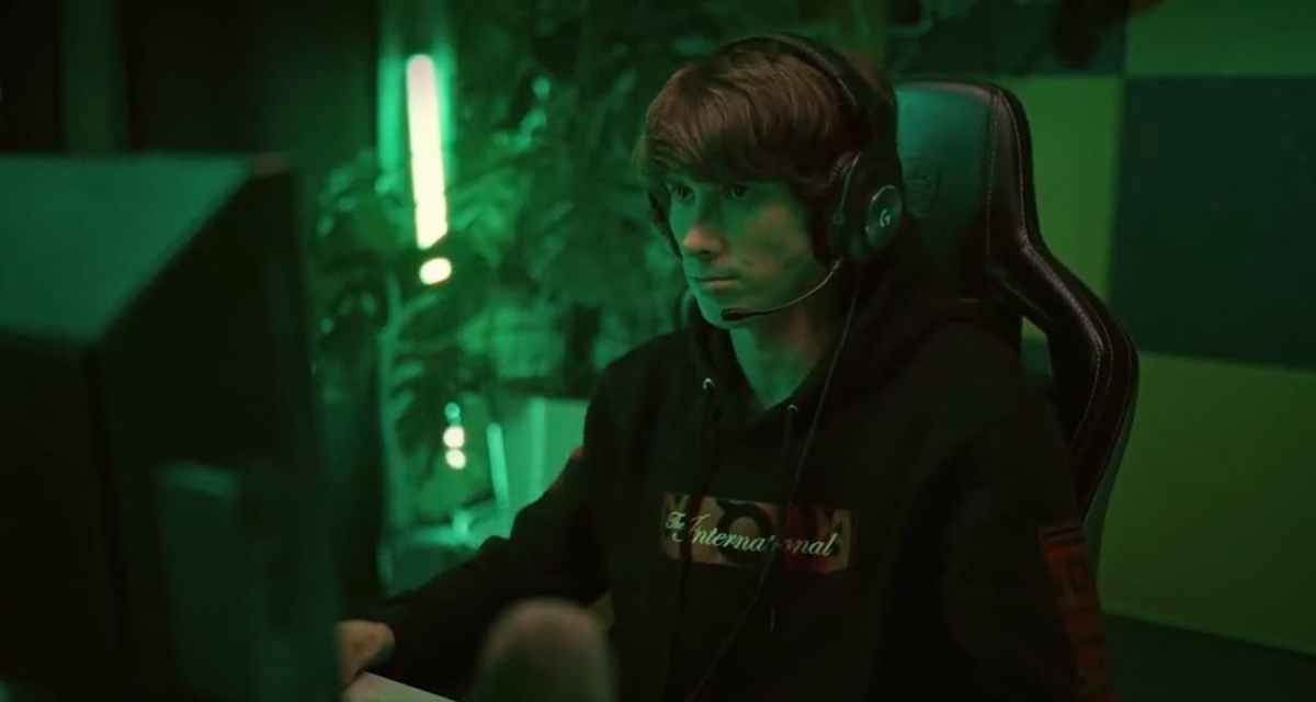 Dendi illuminated by a green light while playing Dota 2.