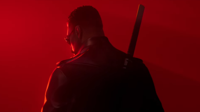 Blade standing in the red background with his back turned to the camera.