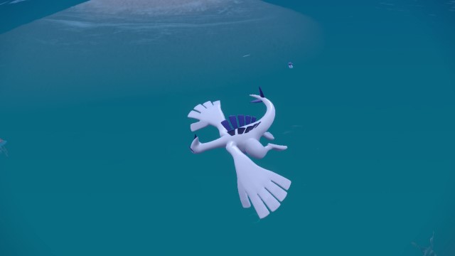 The white and blue flying Lugia spins above the water in Pokémon Scarlet and Violet.