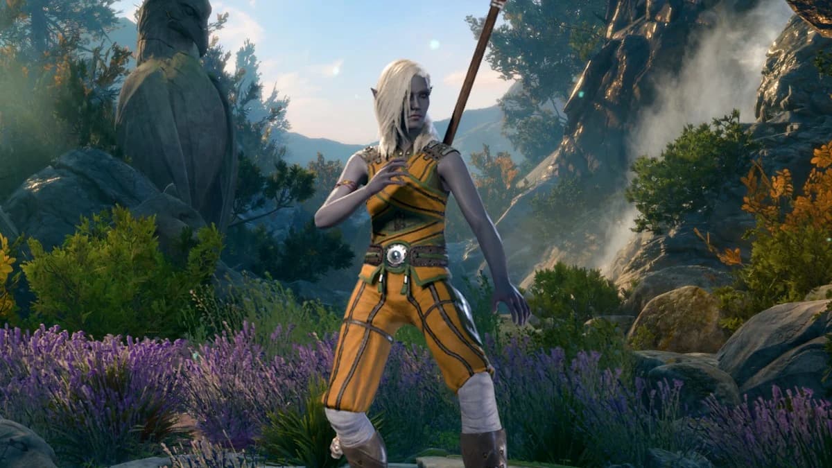 A Dark Elf with long white hair poses in front of a forest scene. they wear a staff on their back.