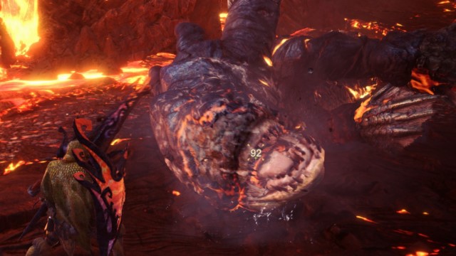 A Lavasioth with a broken head is collapsed in front of a hunter in MHW.