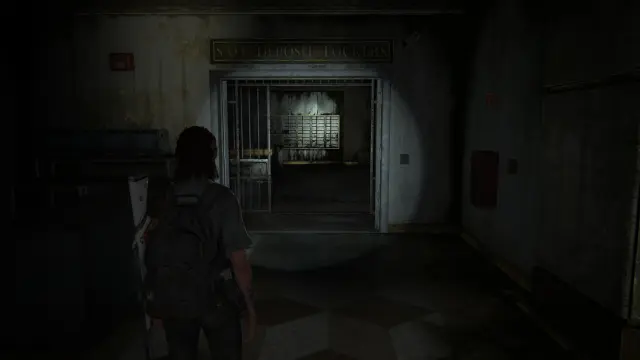 Ellie looks forwards a sign over a door, it says "Safe Deposit Lockers."