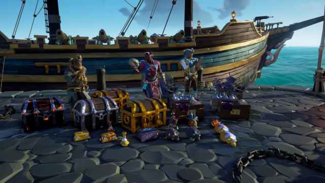 Three pirates surrounded by chests and gold in Sea of Thieves.