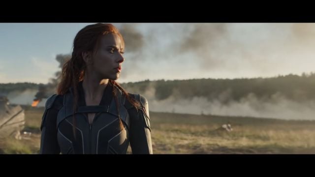 Image of Black Widow looking to the right close to the camera. There is a mountainous landscape in the background.