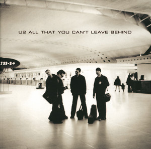 An image of the Beautiful Day cover art, which features three band members standing in black clothes in public. 