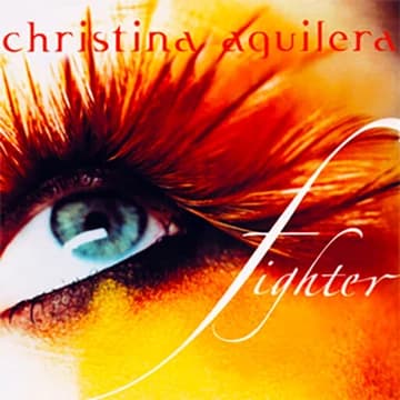 An image of the Fighter cover art, a song by Christina Agilera in Fortnite Festival. This cover features her blue eue with orange makeup. 