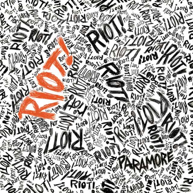 An image of the Misery Business cover art, which features the word Riot in black and red ink. 