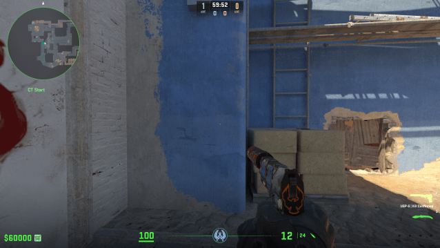 A player holds a pistol staring at a blue wall on Mirage in CS2.