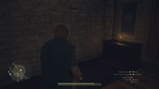 A Dragon's Dogma 2 screenshot that shows the Arisen facing a stone wall in a dim room.