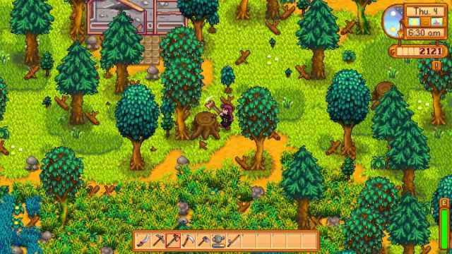 The player chopping down a tree in Stardew Valley.