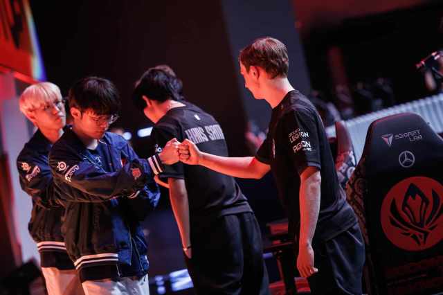 T1 fist bump G2 Esports on stage during MSI Bracket Stage.