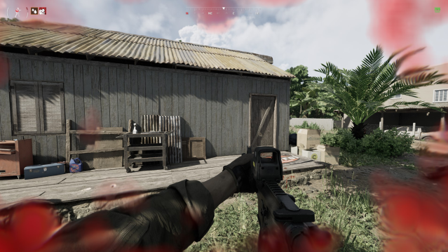 A soldier holds a rifle outside a wood and tin shack in Gray Zone Warfare.