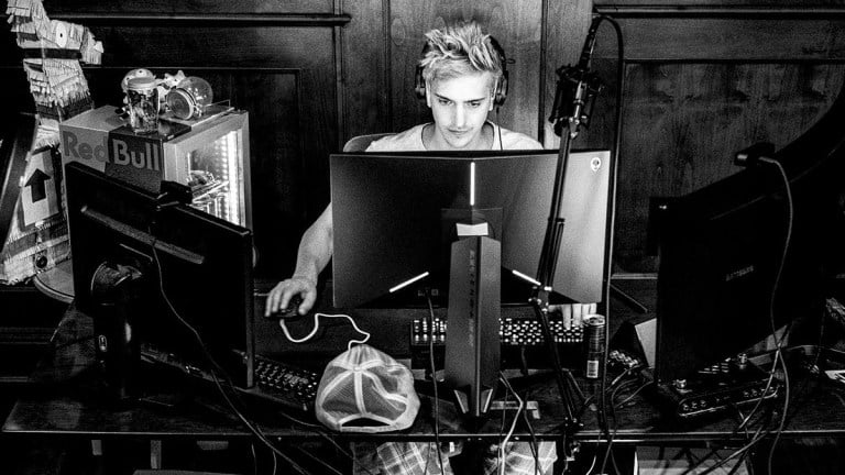 Tyler Blevins, or Ninja, sits at a desk in front of three monitors.