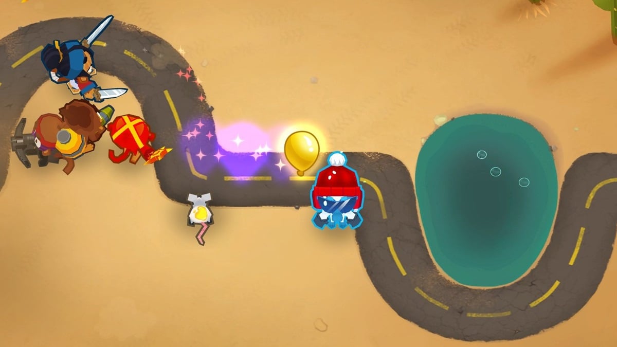 A Golden Bloon appearing near a group of varied monkey towers in BTD6