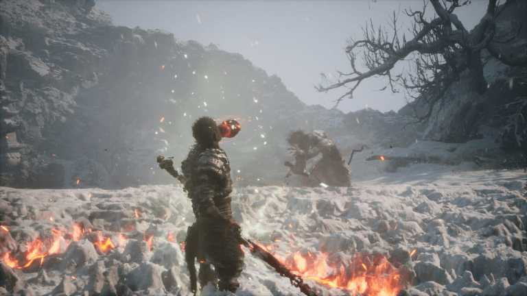 The titular protagonist of Black Myth Wukong facing off against an enemy in a white snowy region in the game