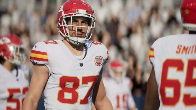 Travis Kelce, a pro football player, wearing a white Kansas City Chiefs jersey with red numbers and a red helmet.