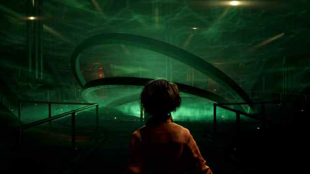 A female character looks at a series of large rings overlapping, enshrouded by green smoke