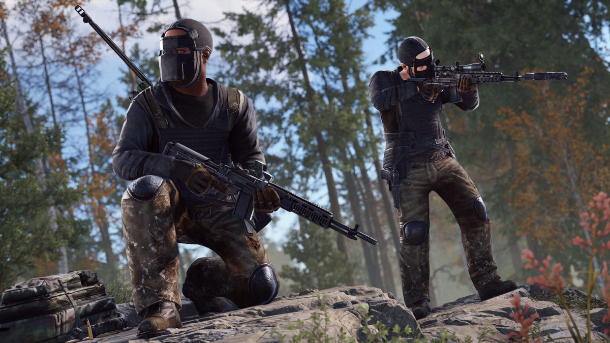 Two Rust players geared up and on the lookout in a jungle with rifles in their hands