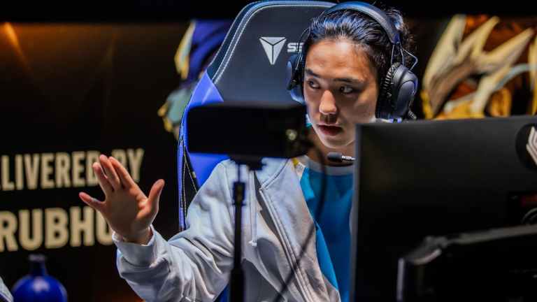 Kim "Berserker" Min-cheol of Cloud9 competes during the 2023 LCS Spring Finals at the PNC Arena, wearing a headset and holding his hand in the air.